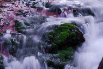 赤茶色の岩に緑色の苔（チャツボミゴケ）がきれいな滝のある風景　-日本、長野県、おしどり隠しの滝