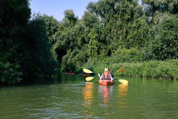 Fototapeta na wymiar People boating at kayak on river at summer time. Peacefull nature scene
