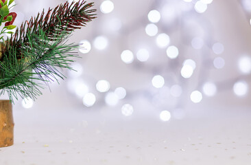 branches of a Christmas tree on a white background. Blurry lights from the garland are visible in the background. Soft focus. Copy space.