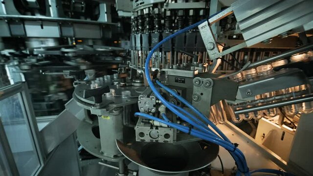 Automatic filling machine pours water into plastic PET bottles at modern beverage plant