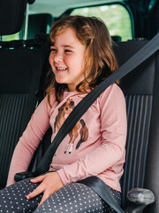 elementary child laugh inside the transport vehicle with seat belt on