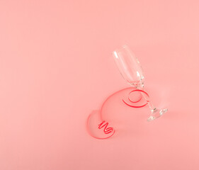 champagne glass against pastel pink background. creative new years decoration idea. creative falt lay. minimalism