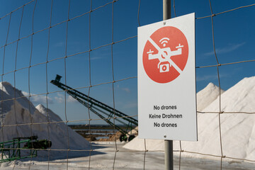 Drone prohibition sign, with text in several languages, on the fence of a salt factory. Mallorca...