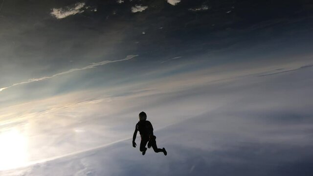 Freefly skydiving. Happy girl is flying in the sunset sky.