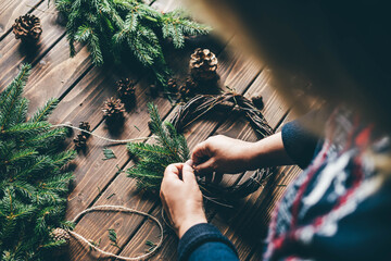 Woman making Christmas wreath close up.