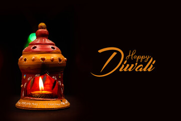 Happy diwali with traditional oil lamp on dark background.