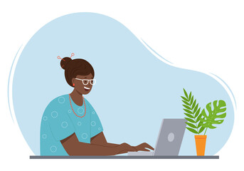 A happy adult woman with dark skin and hair is sitting at a table with a laptop. An adult modern lady in glasses and beads communicates at the computer. Color vector illustration on a spot background.