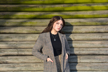 A  girl stands in front of wooden planks
