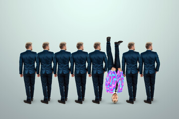 Uniqueness creative background, among the crowd of businessmen a man stands upside down....