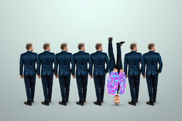 Uniqueness creative background, among the crowd of businessmen a man stands upside down. Competitive advantage, standing out from the crowd, thinking outside the box, a leader.