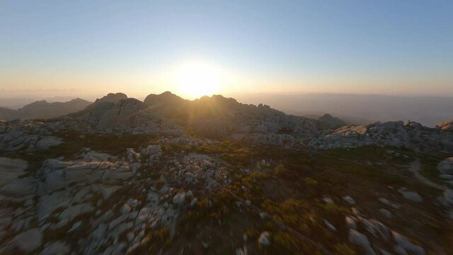 FPV video, mountain surfing, flying at high speed over a granitic mountain range during a beautiful sunrise. Mount Limbara (Monte Limbara) Tempio Pausania, Sardinia, Italy.