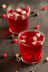 two glasses of currant juice on a gray background