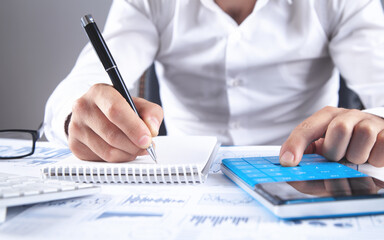 Fototapeta premium Businessman using calculator for analysis marketing plan.