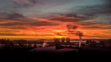 Ein Blick über die Dächer vom Dorf in die weite Landschaft beim Sonnenaufgang.