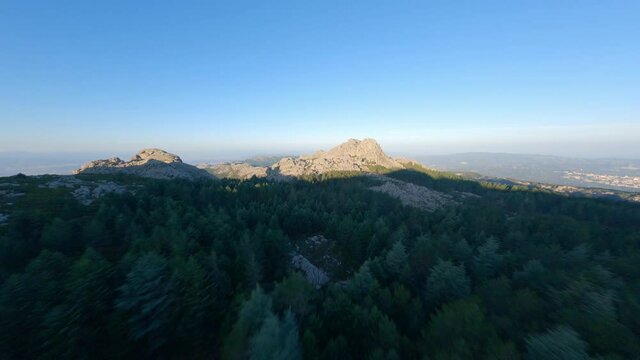 FPV video, mountain surfing, flying at high speed over a granitic mountain range during a beautiful sunrise. Mount Limbara (Monte Limbara) Tempio Pausania, Sardinia, Italy.