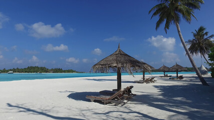 Ideal for a romantic getaway, thatched umbrellas with sun loungers, palm trees, sand and clear ocean