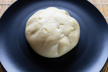 steamed Banh bao, Vietnamese savory filled bun close up, on black plate