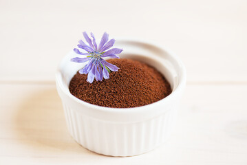 Dry chicory in a white bowl on a wooden table.