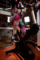 Caucasian woman on fitness bike in gym during workout
