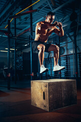 Fototapeta na wymiar Portrait of sportive man, bodybuilder workouts at sport gym, indoors. Concept of sport, activity, healthy lifestyle