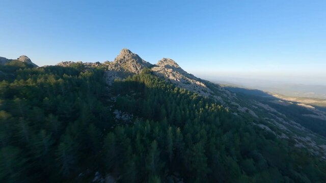 FPV video, mountain surfing, flying at high speed over a granitic mountain range during a beautiful sunrise. Mount Limbara (Monte Limbara) Tempio Pausania, Sardinia, Italy.