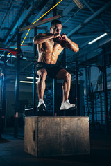 Obraz na płótnie Canvas Portrait of sportive man, bodybuilder workouts at sport gym, indoors. Concept of sport, activity, healthy lifestyle