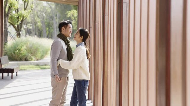 young asian couple lovers hugging outdoors in park