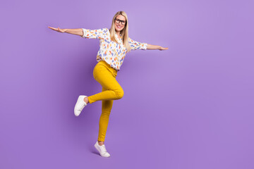 Photo of adorable funny mature lady dressed print blouse glasses walking empty space arms sides smiling isolated purple color background