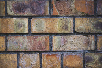 Grey white black red orange old vintage brick wall background. Rustic cemented dark brick house wall texture with grunge surface. Shabby Building Facade With Damaged Plaster. Aged weathered exterior