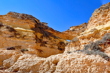 Fototapeta premium Lagos portugiesische goldene Küstenklippen im Süden Treppen und Grotte Postkarten Landschaft Portugal steile Küsten Landschaft Algarve Felsen Strand Meer Ozean Wellen Wasser Küste Ufer 