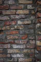 Grey white black red orange old vintage brick wall background. Rustic cemented dark brick house wall texture with grunge surface. Shabby Building Facade With Damaged Plaster. Aged weathered exterior