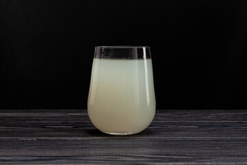 Rejuvelac -  Natural Organic fermented drink in clear glass. Dark background, copy space