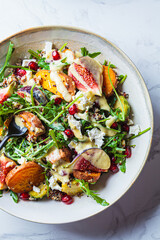 Warm autumn quinoa salad with baked vegetables, figs, feta cheese and pomegranate.