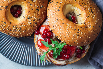 Thanksgiving food concept. Bagel sandwich with turkey and cranberry sauce on a gray plate.