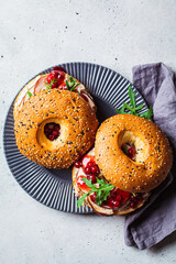 Thanksgiving food concept. Bagel sandwich with turkey and cranberry sauce on a gray plate.