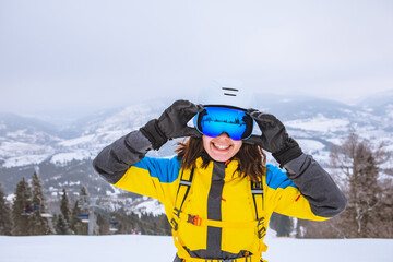 Fototapeta na wymiar young pretty smiling woman in ski outfit with goggles and helmet