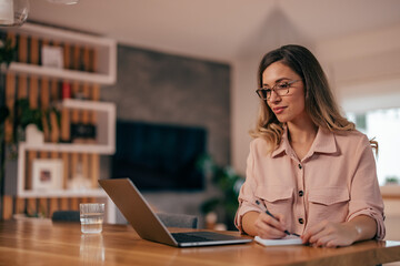 Young woman, taking notes during the meeting.
