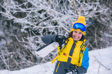 Fototapeta na wymiar smiling gorgeous woman holding ski on shoulder