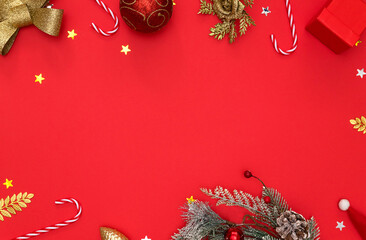 Happy New Year 2022. Golden and red Christmas toys, fir branches on a red background. the concept of a postcard with a top view and space to copy.