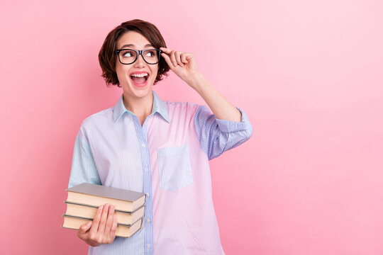 Photo of young excited woman happy positive smile hold books learn look empty space isolated over pastel color background