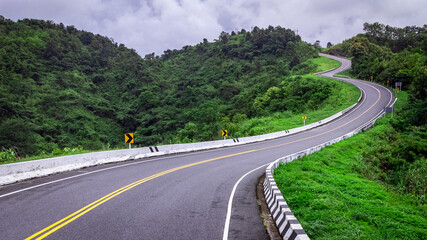 Fototapeta premium Road no.3 or sky road on Root 1081 over top of mountains with green jungle in Santisuk - Bo Kluea District, Nan province, Thailand.