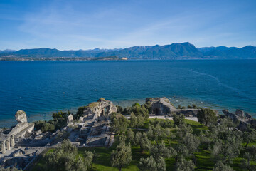 Aerial view of the Grotte di Catullo ruins of a large Roman villa on the peninsula. Olive grove and archaeological museum. Grottoes ruins on the Sirmione peninsula. Lake Garda, Italy.