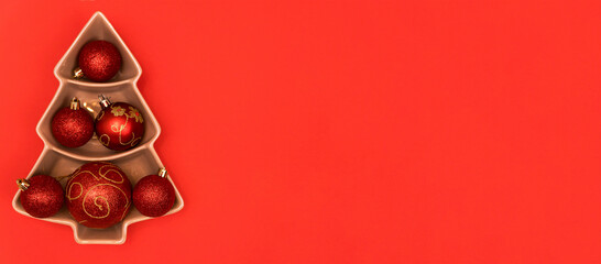 Happy New Year 2022 Christmas tree with Christmas toys on a red background. Postcard. banner. Copy space.