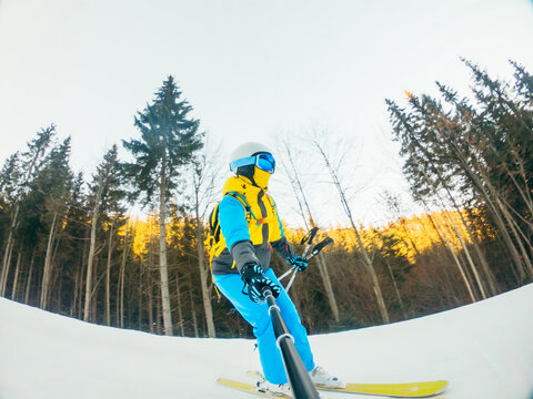 woman skier taking selfie while riding by slope