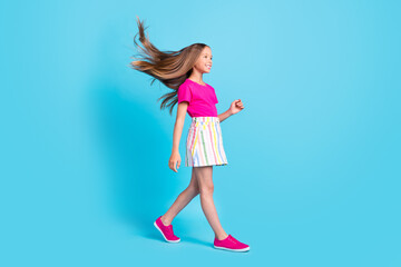 Full body profile side photo of happy cheerful girl walk empty space dream fly hair isolated on blue color background