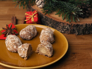 Fototapeta na wymiar Delicious Christmas stollen on a ceramic plate in front of an Advent wreath and Christmas decorations