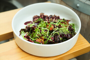 Healthy green salad with veal steak and berry sauce