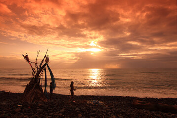 hippy on a beach with wooden shelter teepee with the ocean