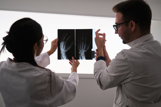 Professional medical team examining hand x-ray image. Rheumatoid arthritis.