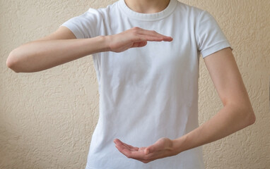 Layout for inserting text. A woman in a white T-shirt holding something on the palms of her open hands. Copy space for object.